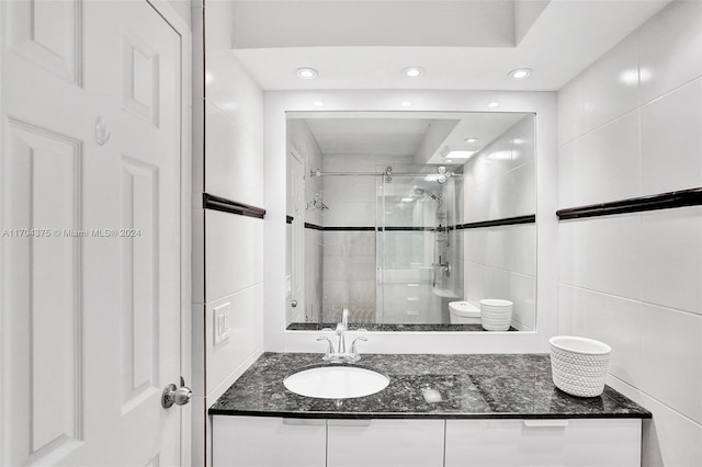 bathroom featuring toilet, vanity, and walk in shower