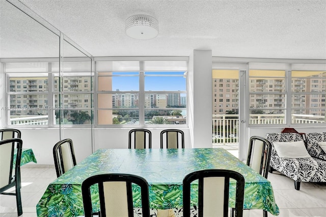 tiled dining space featuring a textured ceiling and a wealth of natural light