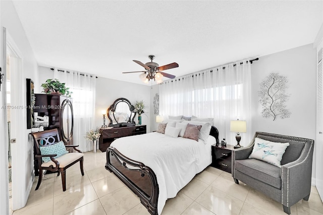 tiled bedroom with multiple windows and ceiling fan