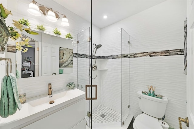 bathroom with vanity, toilet, an enclosed shower, and tile walls