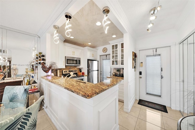 kitchen featuring light tile patterned flooring, stone countertops, white cabinetry, backsplash, and stainless steel appliances