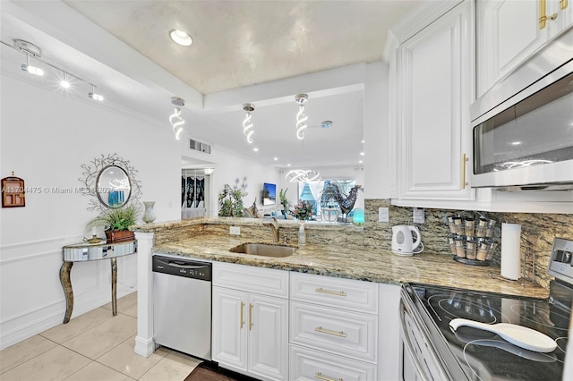 kitchen featuring sink, white cabinetry, appliances with stainless steel finishes, kitchen peninsula, and light stone countertops