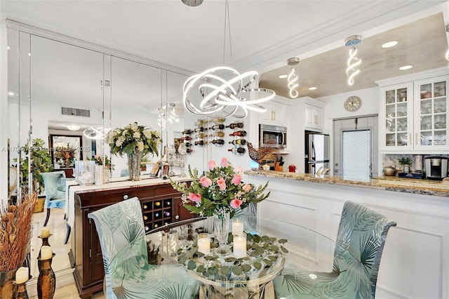 dining area with crown molding and a chandelier