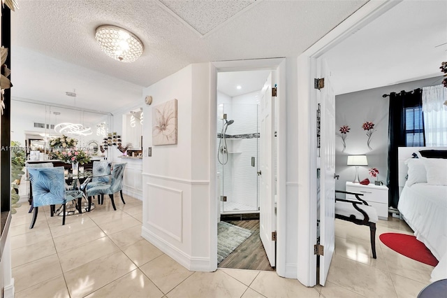 hallway featuring light tile patterned flooring and a textured ceiling