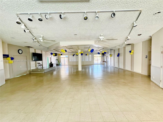 interior space with ceiling fan and a textured ceiling