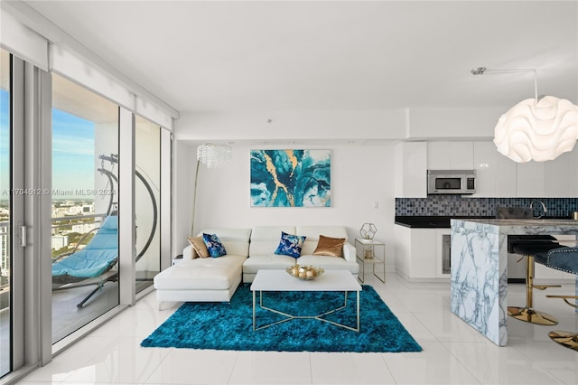 living room featuring sink and light tile patterned floors