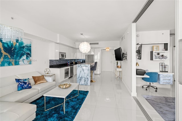 tiled living room featuring sink, built in desk, and a notable chandelier