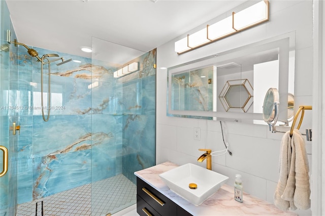 bathroom with vanity, tile walls, and a shower with shower door