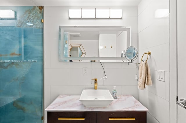 bathroom featuring vanity and tile walls