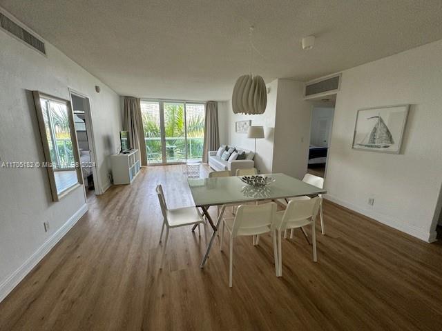 dining area featuring hardwood / wood-style flooring and a textured ceiling