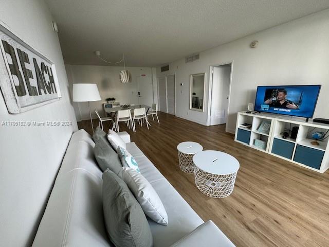 living room featuring wood-type flooring and a textured ceiling