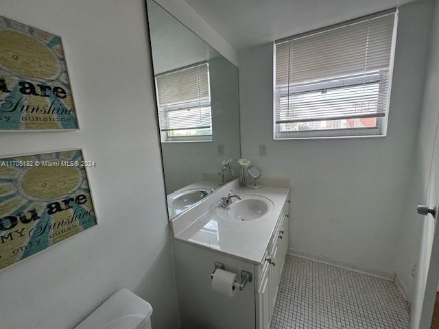 bathroom featuring tile patterned flooring, vanity, and toilet