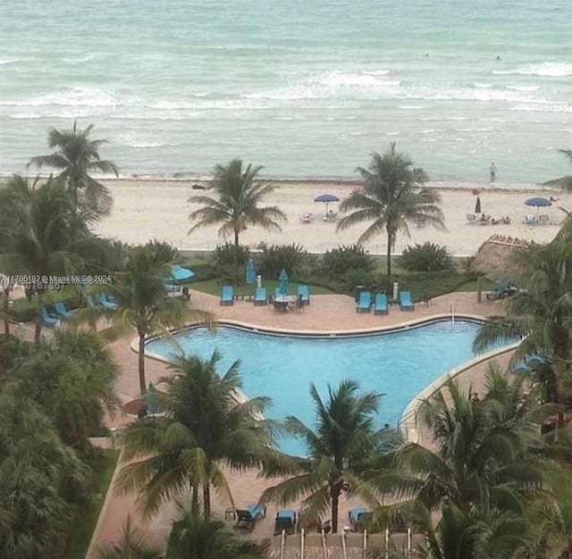 view of swimming pool with a view of the beach and a water view