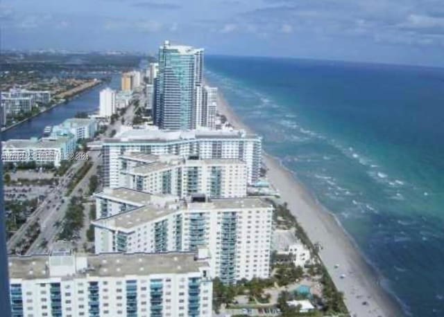 aerial view featuring a water view and a beach view