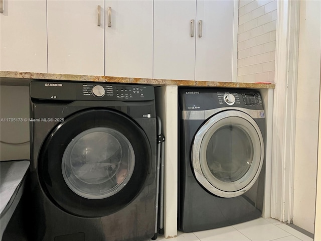 laundry area featuring light tile patterned floors and washing machine and clothes dryer