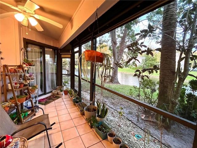 sunroom / solarium featuring ceiling fan and a water view