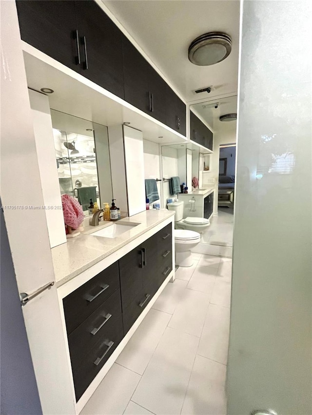 interior space with toilet, vanity, tile patterned floors, a bidet, and a shower with door