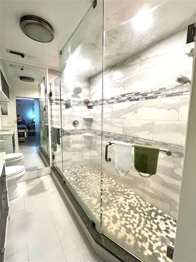 bathroom with toilet, tile patterned floors, an enclosed shower, and vanity