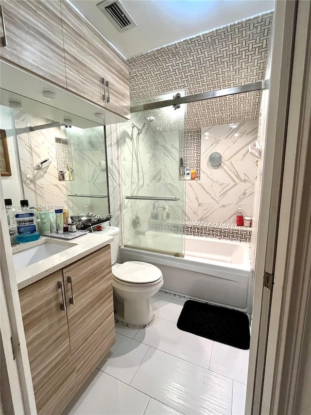 full bathroom with toilet, tile patterned floors, vanity, and shower / bath combination with glass door