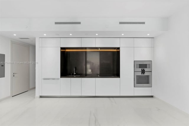 interior space featuring recessed lighting, a sink, visible vents, electric panel, and black stovetop