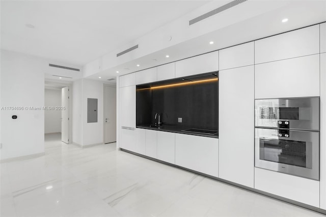 kitchen with visible vents, modern cabinets, white cabinetry, and electric panel