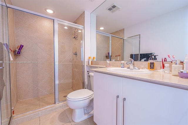 bathroom featuring tile patterned floors, vanity, an enclosed shower, and toilet