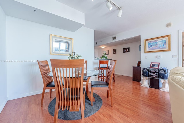 dining space featuring hardwood / wood-style floors and rail lighting