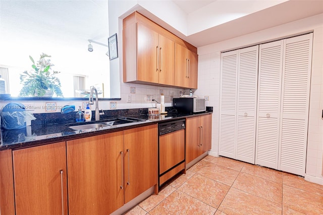 kitchen with dishwasher, sink, dark stone countertops, decorative backsplash, and light tile patterned floors