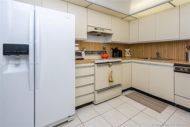 kitchen featuring white cabinetry, sink, light tile patterned flooring, and white appliances