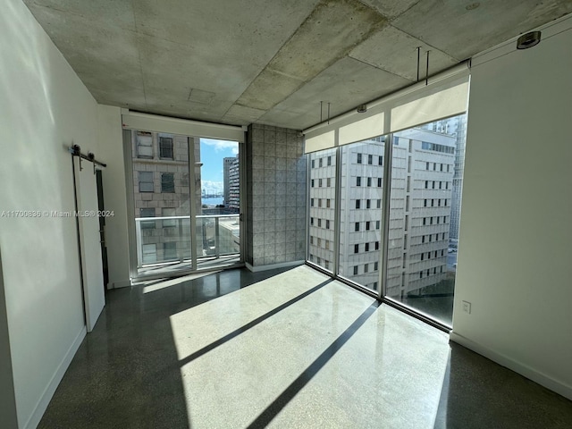 empty room featuring a barn door and floor to ceiling windows