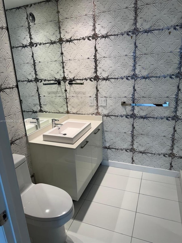 bathroom with tile patterned floors, vanity, tile walls, and toilet