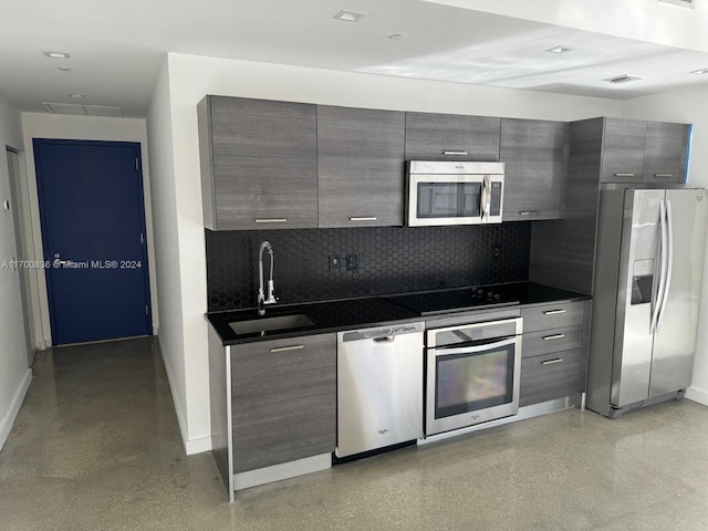 kitchen with appliances with stainless steel finishes, tasteful backsplash, and sink