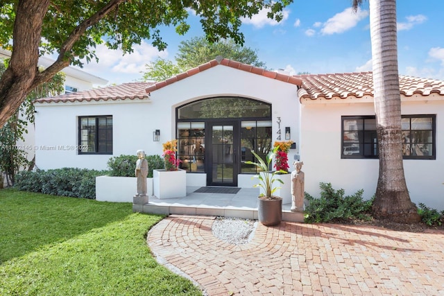 entrance to property with french doors and a yard