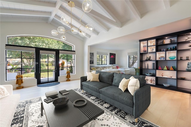 living room with a healthy amount of sunlight, vaulted ceiling with beams, and a notable chandelier