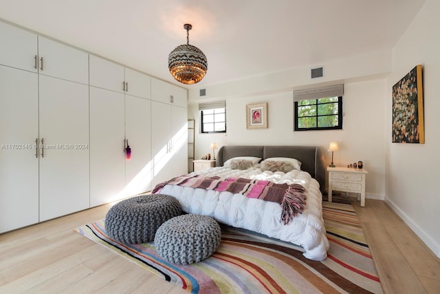 bedroom with light hardwood / wood-style flooring and multiple windows