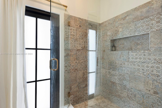 bathroom featuring a shower with door