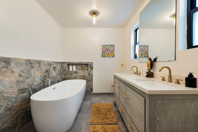 bathroom featuring a bathtub, vanity, tile walls, and tile patterned flooring