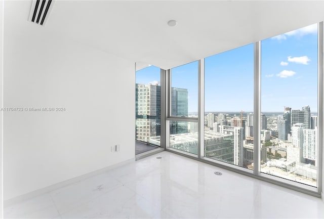 spare room with floor to ceiling windows and plenty of natural light