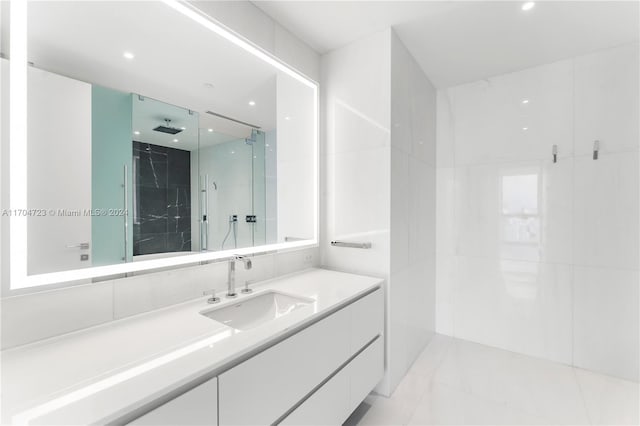 bathroom featuring vanity and a shower with door