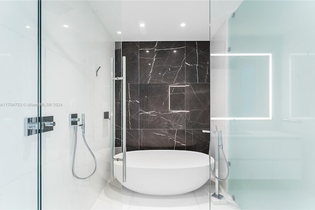 bathroom with tile patterned floors, tile walls, and a bathing tub