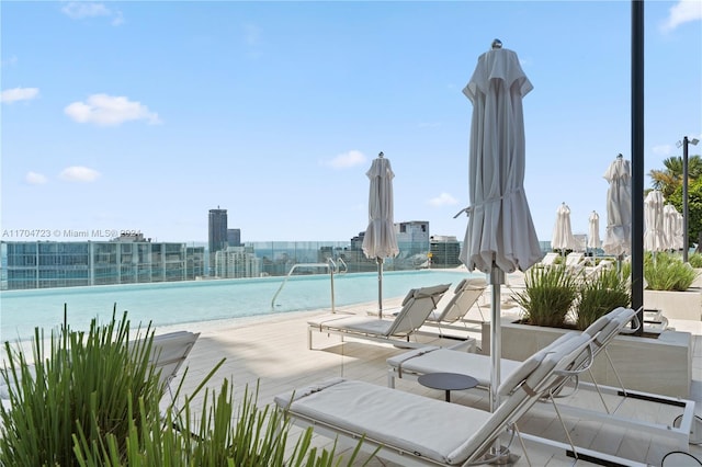 view of swimming pool featuring a water view and a view of the beach