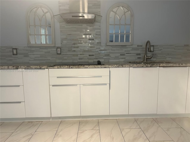 bar featuring white cabinetry, dark stone counters, and range hood