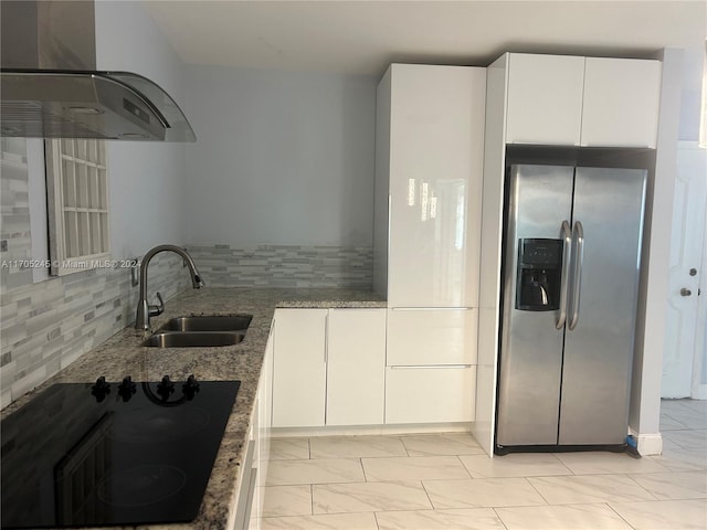 kitchen with stainless steel fridge with ice dispenser, black cooktop, white cabinetry, and sink