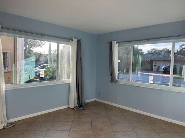 tiled spare room featuring a healthy amount of sunlight