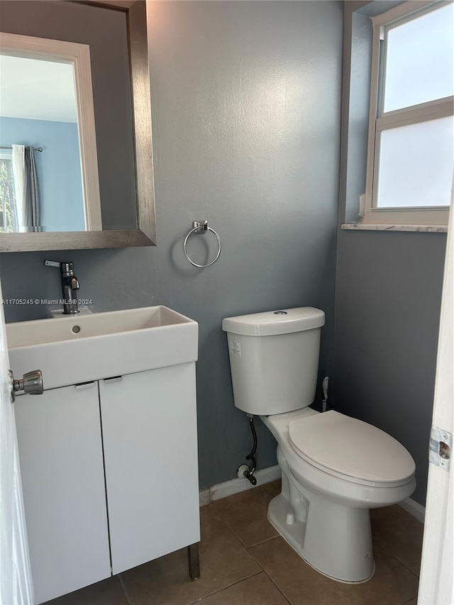 bathroom featuring tile patterned floors, vanity, and toilet