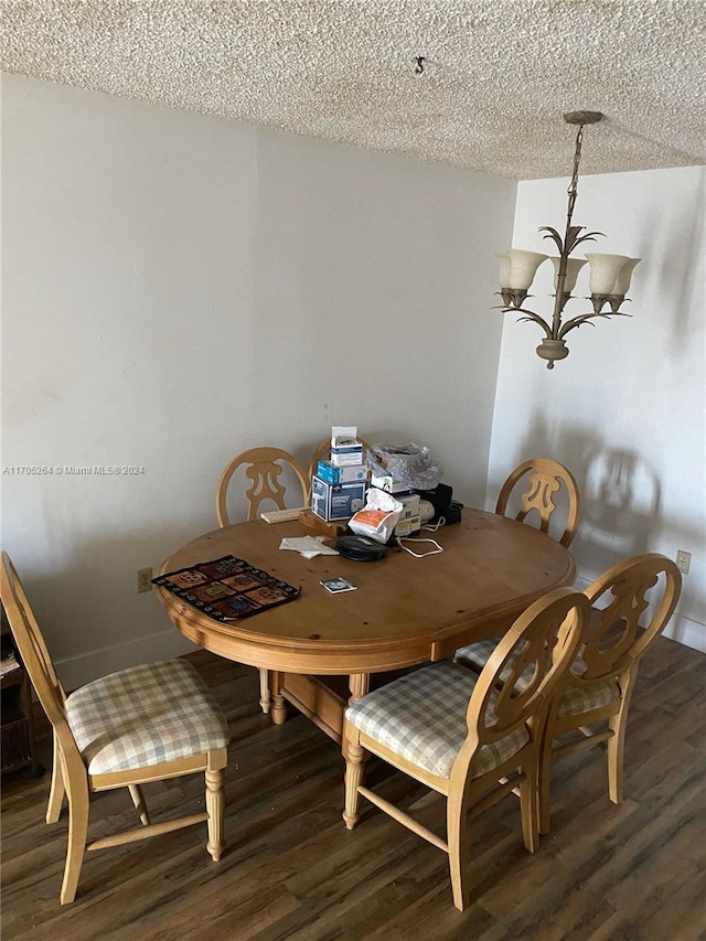 dining space with hardwood / wood-style flooring, a notable chandelier, and a textured ceiling