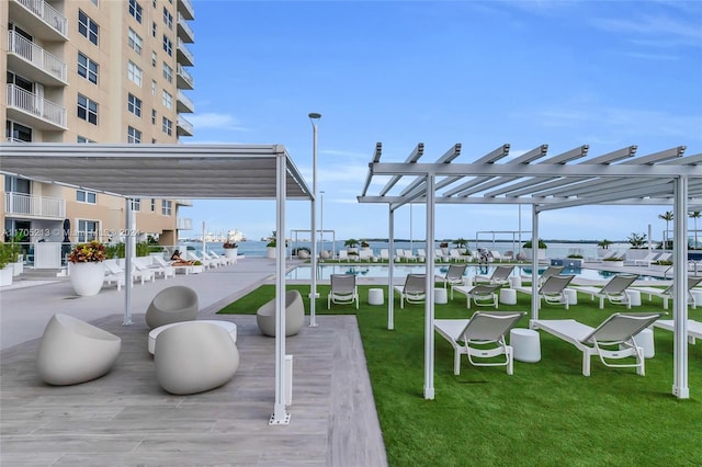 exterior space featuring a pergola, a yard, and a water view