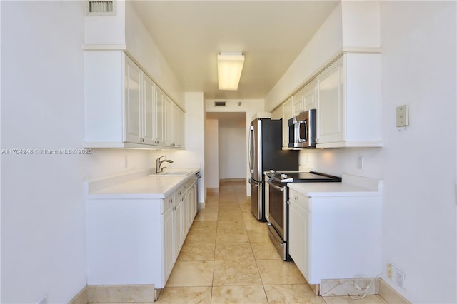 kitchen with visible vents, stainless steel appliances, light countertops, and a sink