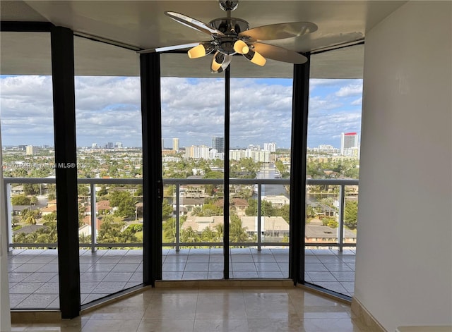 entryway with expansive windows, a view of city, a ceiling fan, and tile patterned flooring