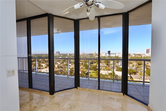 entryway featuring tile patterned flooring, a city view, a ceiling fan, and expansive windows